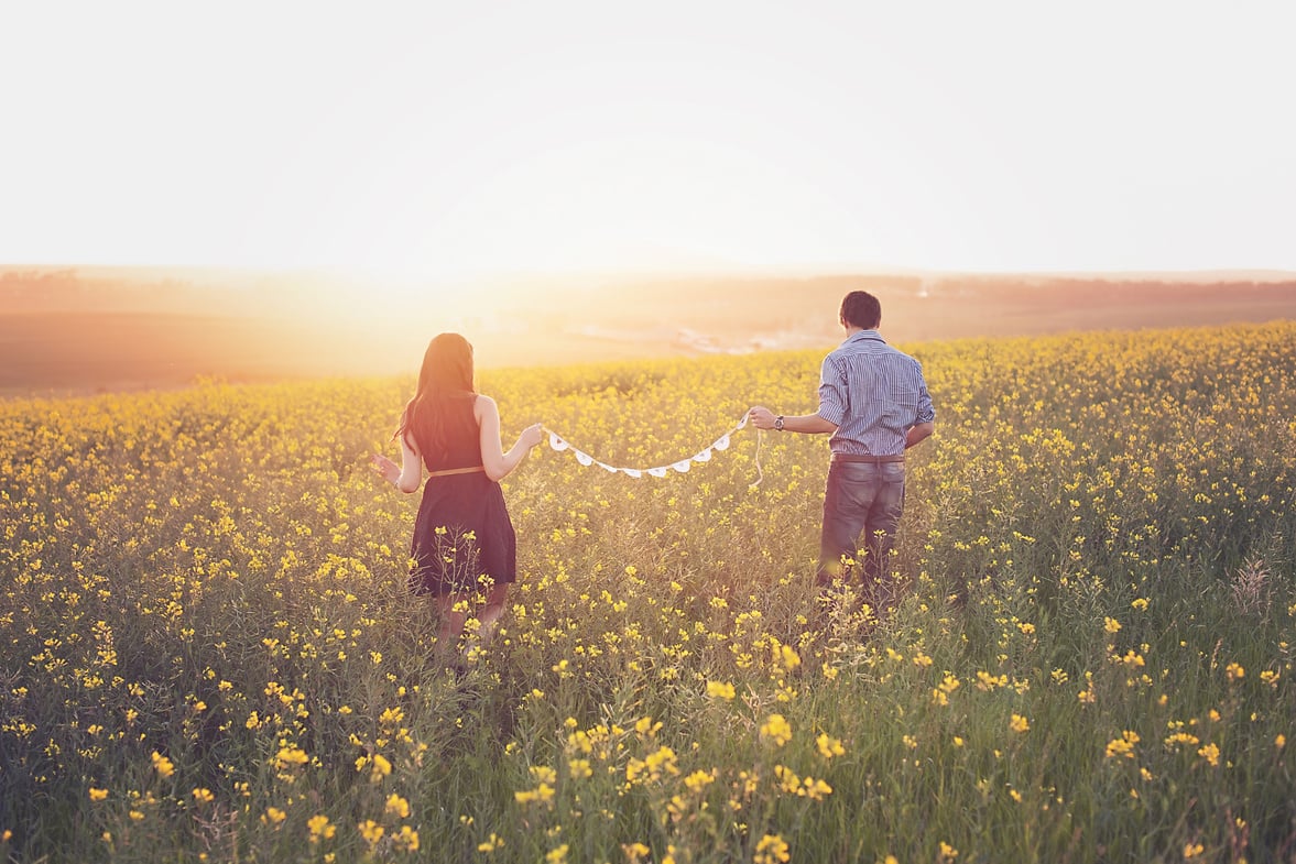 Couple in Canola Field at Sunset